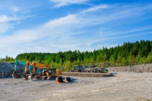 Heavy Construction Equipment, Tractors, Excavators, and Bulldozers Parked in a Forest Parking Lot